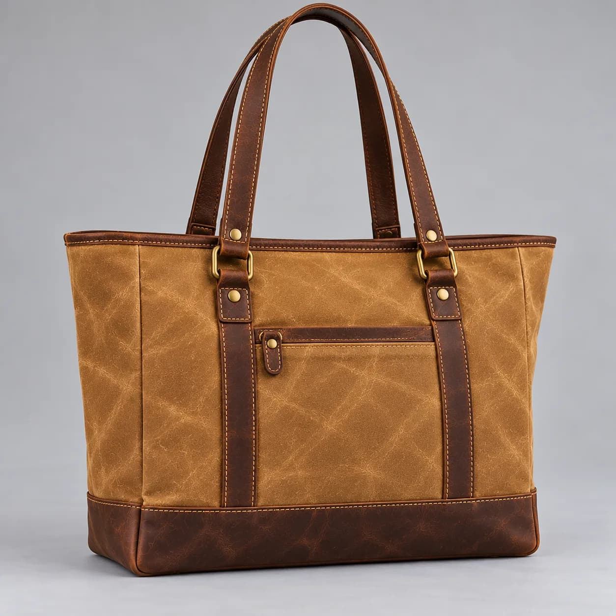Waxed canvas and leather tote bag product direction on a neutral studio background