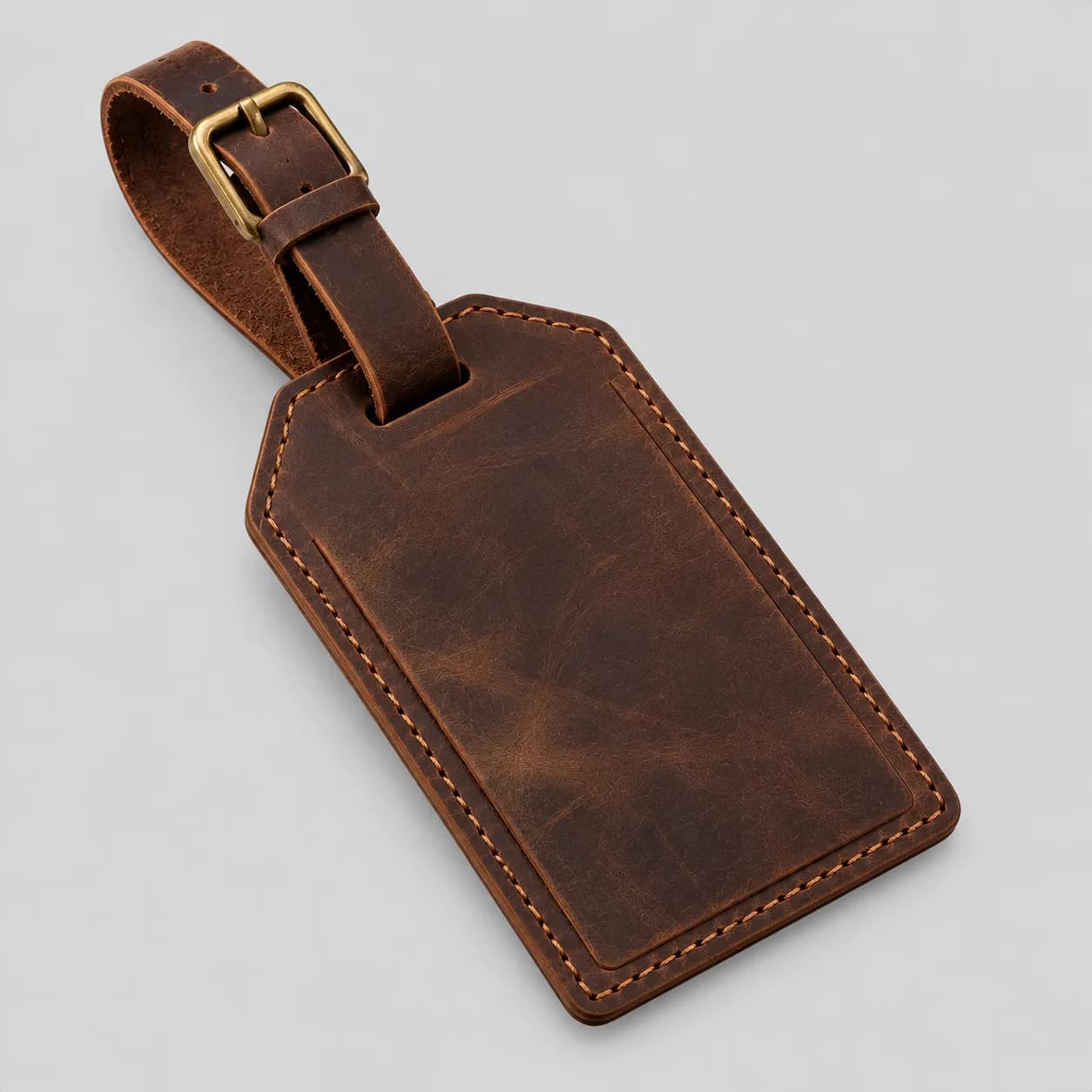 Leather luggage tag product direction on a neutral studio background